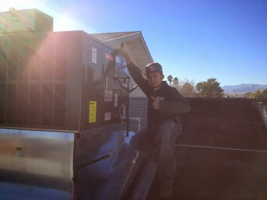 HVAC technician performing Air Duct Repair on a rooftop unit in Moyock